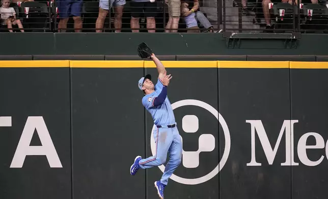 Texas Rangers left fielder Wyatt Langford makes a leaping catch on a flyout by Tampa Bay Rays' Josh Lowe in the seventh inning of a baseball game in Arlington, Texas, Sunday, July 7, 2024. (AP Photo/Tony Gutierrez)