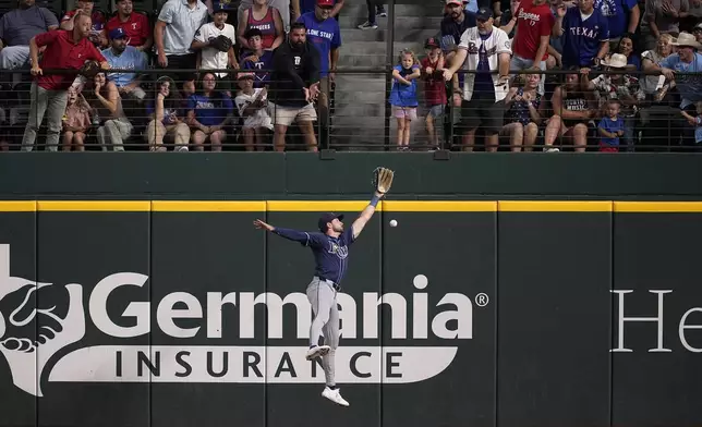 Fans look on as Tampa Bay Rays right fielder Josh Lowe is unable to reach a double by Texas Rangers' Jonah Heim in the second inning of a baseball game in Arlington, Texas, Sunday, July 7, 2024. (AP Photo/Tony Gutierrez)