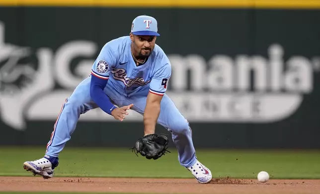 Texas Rangers second baseman Marcus Semien fields a double play ball hit by Tampa Bay Rays' Brandon Lowe in the first inning of a baseball game in Arlington, Texas, Sunday, July 7, 2024. Rays' Yandy Diaz was out at second on the play. (AP Photo/Tony Gutierrez)