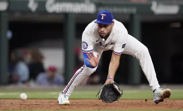 Texas Rangers third baseman Jonathan Ornelas reaches out to field a ground ball hit by Tampa Bay Rays' Jonny DeLuca in the second inning of a baseball game in Arlington, Texas, Saturday, July 6, 2024. DeLuca was out at first on the play. (AP Photo/Tony Gutierrez)