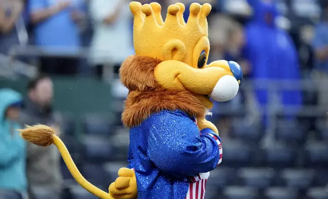 Dressed in patriotic colors, Kansas City Royals mascot Sluggger stands for the national anthem before a baseball game between the Kansas City Royals and the Tampa Bay Rays Wednesday, July 3, 2024, in Kansas City, Mo. (AP Photo/Charlie Riedel)