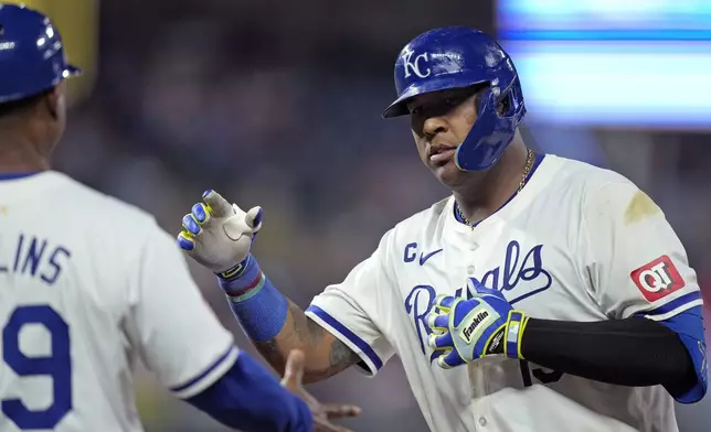 Kansas City Royals' Salvador Perez, celebrates with first base coach Damon Hollins after hitting an RBI single during the seventh inning of a baseball game against the Tampa Bay Rays Wednesday, July 3, 2024, in Kansas City, Mo. (AP Photo/Charlie Riedel)