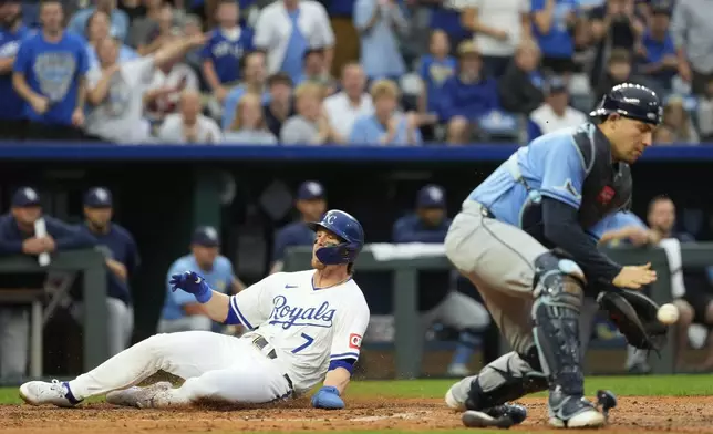 Kansas City Royals' Bobby Witt Jr. (7) slides home past Tampa Bay Rays' Alex Jackson to score on a double by Vinnie Pasquantino during the third inning of a baseball game Wednesday, July 3, 2024, in Kansas City, Mo. (AP Photo/Charlie Riedel)