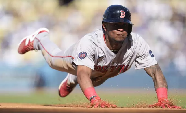 Boston Red Sox's Ceddanne Rafaela slides headfirst into third base after a pop fly by Tyler O'Neill during the third inning of a baseball game against the Los Angeles Dodgers, Saturday, July 20, 2024, in Los Angeles. Rafaela was out at third on a double play. (AP Photo/Marcio Jose Sanchez)