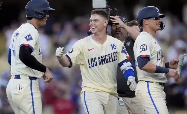 Los Angeles Dodgers' Will Smith, center, celebrates with Shohei Ohtani, left, and Kiké Hernández, right, after driving in the winning run with a single during the eleventh inning of a baseball game against the Boston Red Sox, Saturday, July 20, 2024, in Los Angeles. (AP Photo/Marcio Jose Sanchez)