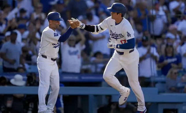 Los Angeles Dodgers designated hitter Shohei Ohtani, right, celebrates his solo home run with third base coach Dino Abel during the fifth inning of a baseball game against the Boston Red Sox, Sunday, July 21, 2024, in Los Angeles. (AP Photo/Ryan Sun)