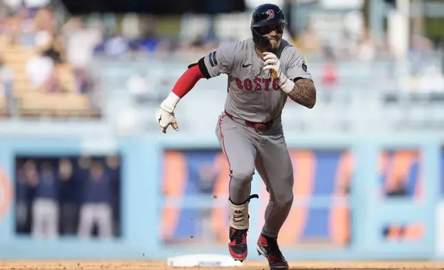 Boston Red Sox's Jarren Duran advances to third base after his two-run double following a throwing error from Los Angeles Dodgers shortstop Miguel Rojas during the fifth inning of a baseball game Saturday, July 20, 2024, in Los Angeles. (AP Photo/Marcio Jose Sanchez)