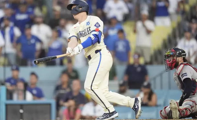 Los Angeles Dodgers' Will Smith, left, drives in the winning run with a single during the 11th inning of a baseball game against the Boston Red Sox, Saturday, July 20, 2024, in Los Angeles. (AP Photo/Marcio Jose Sanchez)