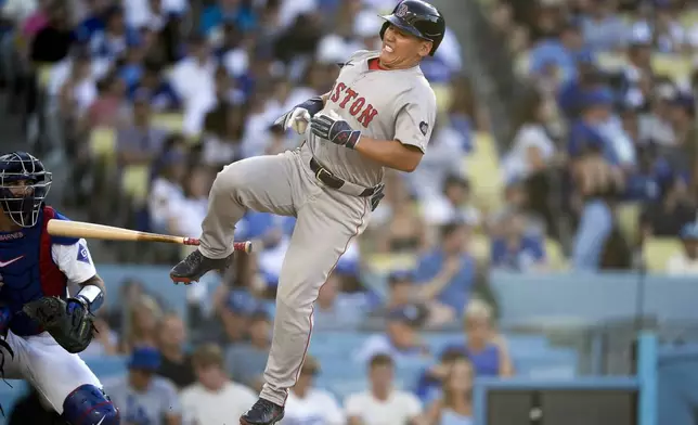 Boston Red Sox designated hitter Masataka Yoshida, right, reacts after being hit by a pitch from Los Angeles Dodgers reliever Anthony Banda during the eighth inning of a baseball game, Sunday, July 21, 2024, in Los Angeles. (AP Photo/Ryan Sun)