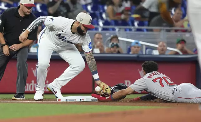 Miami Marlins third baseman Emmanuel Rivera (15) fails to catch the ball as Boston Red Sox's David Hamilton (70) steals the base during the first inning of a baseball game, Thursday, July 4, 2024, in Miami. (AP Photo/Marta Lavandier)