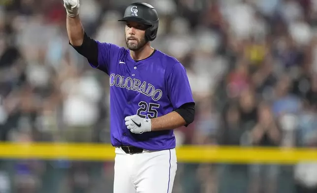 Colorado Rockies' Jacob Stallings gestures to the dugout after reaching second base on an RBI double off Boston Red Sox pitcher Josh Winckowski in the seventh inning of a baseball game Monday, July 22, 2024, in Denver. (AP Photo/David Zalubowski)