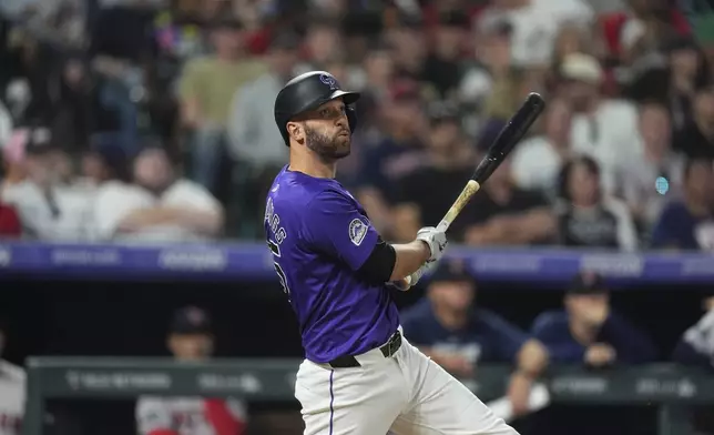 Colorado Rockies' Jacob Stallings follows the flight of his RBI double off Boston Red Sox pitcher Josh Winckowski in the seventh inning of a baseball game Monday, July 22, 2024, in Denver. (AP Photo/David Zalubowski)