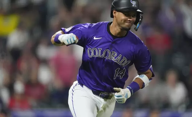 Colorado Rockies' Ezequiel Tovar smiles as he gestures to the dugout while heading up the first-base line after hitting a walkoff RBI single off Boston Red Sox relief pitcher Chase Anderson in the 12th inning of a baseball game Monday, July 22, 2024, in Denver. (AP Photo/David Zalubowski)