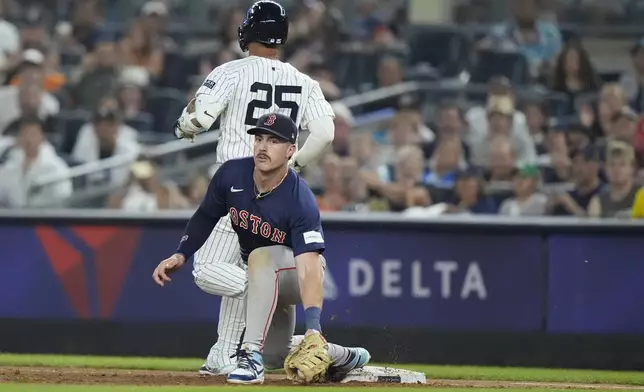 New York Yankees' Gleyber Torres (25) runs past Boston Red Sox's Romy Gonzalez, bottom, for a single during the fourth inning of a baseball game, Friday, July 5, 2024, in New York. Torres was injured on the play. (AP Photo/Frank Franklin II)