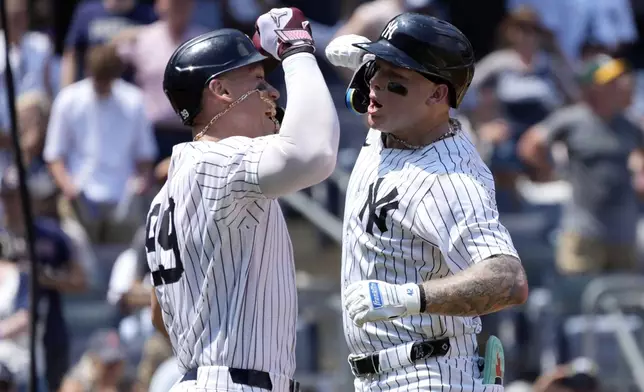 New York Yankees' Aaron Judge, left, and Alex Verdugo celebrate after Verdugo hit a home run during the third inning of a baseball game against the Boston Red Sox, Saturday, July 6, 2024, in New York. (AP Photo/Pamela Smith)