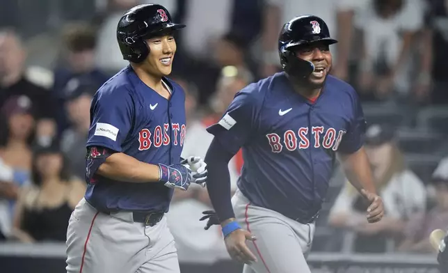 Boston Red Sox's Masataka Yoshida, left, of Japan, and Dominic Smith, right, celebrate after they scored on a two-run home run by Yoshida during the ninth inning of a baseball game against the New York Yankees, Friday, July 5, 2024, in New York. (AP Photo/Frank Franklin II)