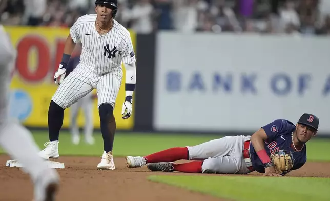 New York Yankees' Oswaldo Cabrera, left, and Boston Red Sox's Ceddanne Rafaela, right, look at the ball Rafaela lost control of on a throwing error by second base Enmanuel Valdez during the fourth inning of a baseball game, Friday, July 5, 2024, in New York. Yankees' Juan Soto scored on the play. (AP Photo/Frank Franklin II)