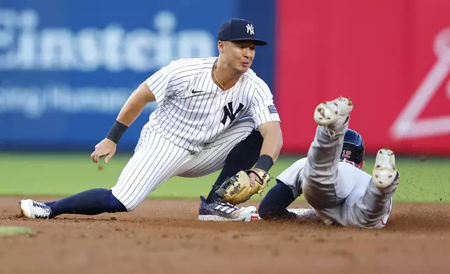 New York Yankees shortstop Anthony Volpe, left, tags out Boston Red Sox's Connor Wong, right, at second base during the second inning of a baseball game, Sunday, July 7, 2024, in New York. (AP Photo/Noah K. Murray)