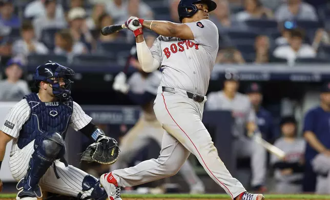 Boston Red Sox's Rafael Devers follows through on a home run against the New York Yankees during seventh inning of a baseball game, Sunday, July 7, 2024, in New York. (AP Photo/Noah K. Murray)