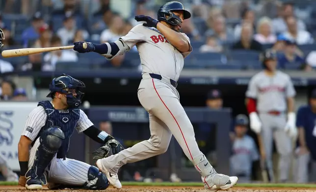 Boston Red Sox's Dominic Smith, right, follows through on a double during the third inning of a baseball game against the New York Yankees, Sunday, July 7, 2024, in New York. (AP Photo/Noah K. Murray)