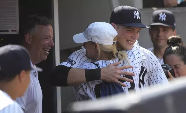 New York Yankees' Ben Rice, center right, hugs family after winning a baseball game against the Boston Red Sox, Saturday, July 6, 2024, in New York. (AP Photo/Pamela Smith)