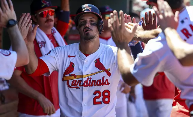 St. Louis Cardinals' Nolan Arenado (28) is congratulated by teammates after scoring a run on an RBI double hit by Masyn Winn during the sixth inning of a baseball game against the Cincinnati Reds, Sunday, June 30, 2024, in St. Louis. (AP Photo/Scott Kane)