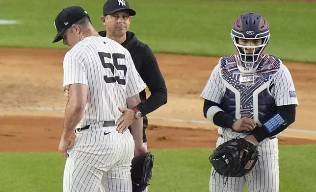 New York Yankees catcher Jose Trevino, right, watches as manager Aaron Boone takes pitcher Carlos Rodón, left, out of the game during the sixth inning of a baseball game against the Cincinnati Reds, Wednesday, July 3, 2024, in New York. (AP Photo/Frank Franklin II)