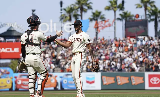 San Francisco Giants pitcher Camilo Doval, right, celebrates with catcher Patrick Bailey, left, after their victory over the Colorado Rockies in a baseball game in San Francisco, Sunday, July 28, 2024. (AP Photo/Kavin Mistry)