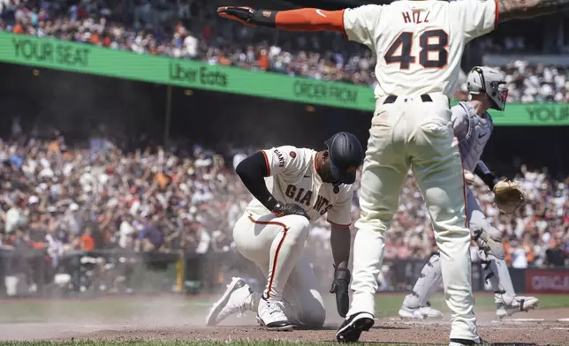 San Francisco Giants' Jorge Soler and Derek Hill (48) celebrate scoring against the Colorado Rockies in the sixth inning of a baseball game in San Francisco, Sunday, July 28, 2024. (AP Photo/Kavin Mistry)