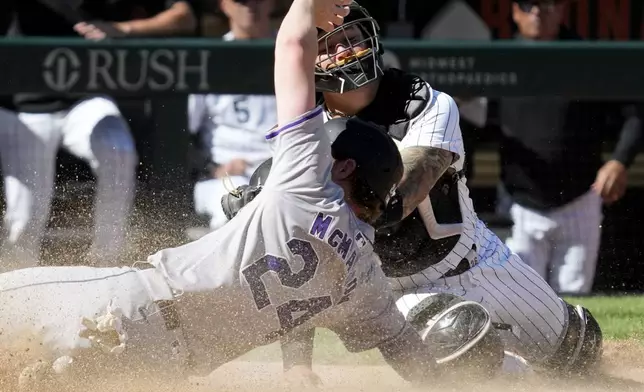Colorado Rockies' Ryan McMahon (24) scores on a sacrifice fly by Michael Toglia as Chicago White Sox catcher Martín Maldonado, top, applies a late tag during the 14th inning of a baseball game in Chicago, Sunday, June 30, 2024. (AP Photo/Nam Y. Huh)