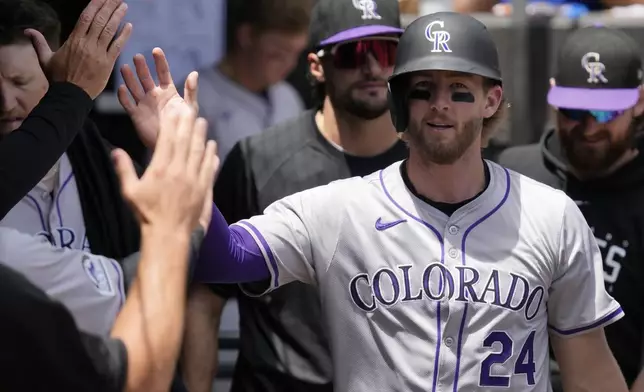 Colorado Rockies' Ryan McMahon celebrates with teammates after scoring on a balk by Chicago White Sox starting pitcher Garrett Crochet during the second inning of a baseball game in Chicago, Sunday, June 30, 2024. (AP Photo/Nam Y. Huh)