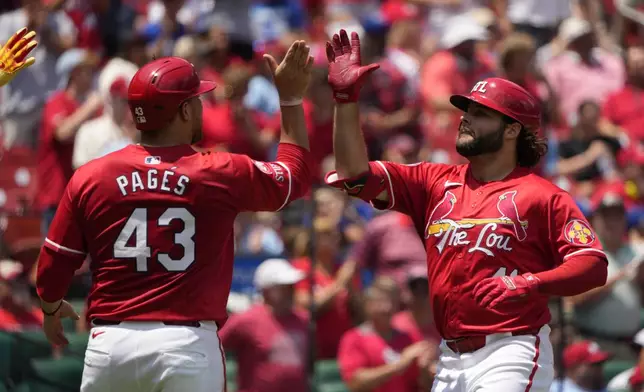 St. Louis Cardinals' Alec Burleson, right, is congratulated by teammate Pedro Pages (43) after hitting a two-run home run during the third inning in the first game of a baseball doubleheader against the Kansas City Royals Wednesday, July 10, 2024, in St. Louis. (AP Photo/Jeff Roberson)