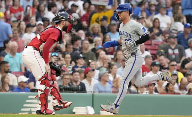 Kansas City Royals' Adam Frazier scores in front of Boston Red Sox catcher Connor Wong on a sacrifice fly by Salvador Perez during the first inning of a baseball game, Friday, July 12, 2024, in Boston. (AP Photo/Michael Dwyer)