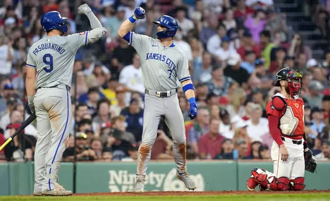 Kansas City Royals' Bobby Witt Jr. (7) celebrates after his solo home run with Vinnie Pasquantino (9) as Boston Red Sox catcher Connor Wong, right, kneels at home plate during the fourth inning of a baseball game, Friday, July 12, 2024, in Boston. (AP Photo/Michael Dwyer)