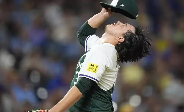 Colorado Rockies relief pitcher Victor Vodnik adjusts his cap before facing Kansas City Royals' Freddy Fermin in the ninth inning of a baseball game Saturday, July 6, 2024, in Denver. (AP Photo/David Zalubowski)