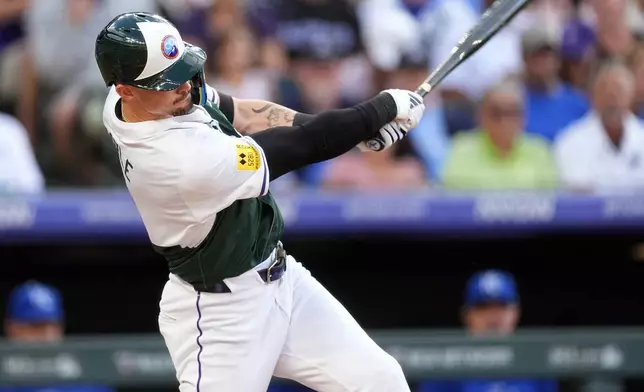 Colorado Rockies' Brenton Doyle follows through with his swing after connecting for a two-run home run off Kansas City Royals starting pitcher Seth Lugo in the second inning of a baseball game Saturday, July 6, 2024, in Denver. (AP Photo/David Zalubowski)