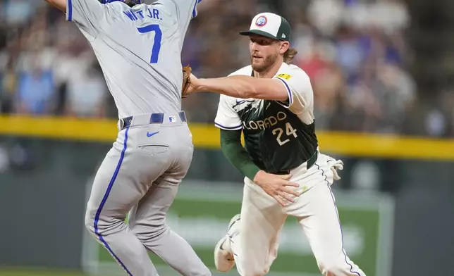 Colorado Rockies third baseman Ryan McMahon, right, tags out Kansas City Royals' Bobby Witt Jr. after he was caught in a rundown between first and second bases in the eighth inning of a baseball game Saturday, July 6, 2024, in Denver. (AP Photo/David Zalubowski)