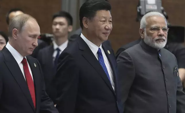 FILE - Russian President Vladimir Putin, left, Chinese President Xi Jinping, center, and Indian Prime Minister Narendra Modi arrive for the Dialogue of Emerging Market and Developing Countries on the sideline of the BRICS Summit in Xiamen, China, on Sept. 5, 2017. (Wu Hong/Pool Photo via AP, File)