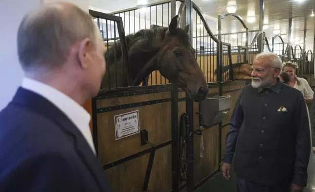 Indian Prime Minister Narendra Modi, right, and Russian President Vladimir Putin visit a stable during an informal meeting at Novo-Ogaryovo residence, outside Moscow, Russia, Monday, July 8, 2024. (Gavial Grigorov, Sputnik, Kremlin Pool Photo via AP)