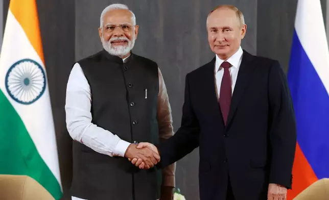 FILE - Russian President Vladimir Putin, right, and Indian Prime Minister Narendra Modi pose for a photo shaking hands prior to their talks on the sidelines of the Shanghai Cooperation Organisation (SCO) summit in Samarkand, Uzbekistan, on Sept. 16, 2022. Modi on Monday begins a two-day visit to Russia that is his first since Moscow sent troops into Ukraine, a conflict that has complicated the relationship between the longtime allies by pushing Russia closer to India's rival China. (Alexandr Demyanchuk, Sputnik, Kremlin Pool Photo via AP, File)