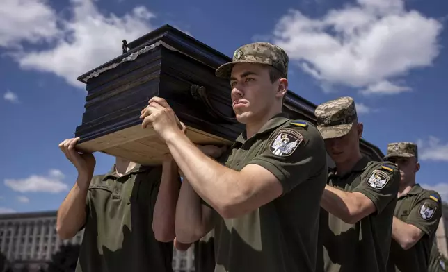 Ukrainian servicemen carry a coffin of British combat medic, volunteer, Peter Fouche, 49 who was killed on June 27 during his work in East Ukraine, at the funeral ceremony on the city's main square in Kyiv, Ukraine, Saturday, July 6, 2024. Peter was founder of a charity organization, which provides vehicles, drones and other needs to Ukrainian servicemen. (AP Photo/Alex Babenko)