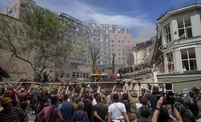 Rescue workers at the site of Okhmatdyt children’s hospital hit by Russian missiles, in Kyiv, Ukraine, Monday, July 8, 2024. Russian missiles have killed at least seven people and struck a children’s hospital in the Ukrainian capital, Kyiv, authorities say. (AP Photo/Evgeniy Maloletka)