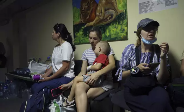 People take shelter in a basement after a Russian missile hit the country's main children's hospital Okhmadit in Kyiv, Ukraine, Monday, July 8, 2024. The daytime barrage targeted five Ukrainian cities with more than 40 missiles of different types hitting apartment buildings and public infrastructure, President Volodymyr Zelenskyy said on social media. (AP Photo/Anton Shtuka)