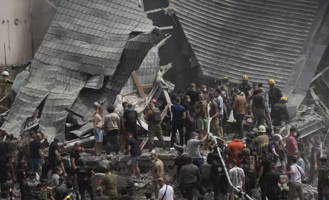 Rescuers and volunteers clean up the rubble and search victims after Russian missile hit the country's main children hospital Okhmadit during massive missile attack on many Ukrainian cities in Kyiv, Ukraine, Monday, July 8, 2024. A major Russian missile attack across Ukraine killed at least 20 people and injured more than 50 on Monday, officials said, with one missile striking a large children’s hospital in the capital, Kyiv, where emergency crews searched rubble for casualties. (AP Photo/Efrem Lukatsky)