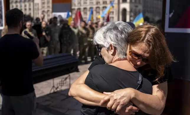 Women hug each other during the funeral ceremony of Peter Fouche, 49 who was killed on June 27 during his work in East Ukraine, on the city's main square in Kyiv, Ukraine, Saturday, July 6, 2024. Peter was founder of a charity organization, which provides vehicles, drones and other needs to Ukrainian servicemen. (AP Photo/Alex Babenko)