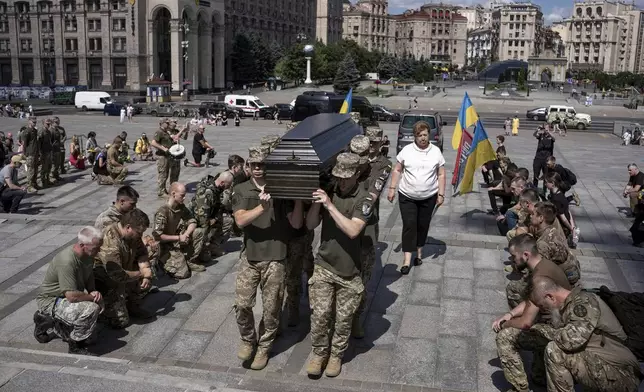 Ukrainian servicemen carry the coffin of British combat medic, volunteer, Peter Fouche, 49 who was killed on June 27 during his work in East Ukraine, at the funeral ceremony on the city's main square in Kyiv, Ukraine, Saturday, July 6, 2024. Peter was founder of a charity organization, which provides vehicles, drones and other needs to Ukrainian servicemen. (AP Photo/Alex Babenko)