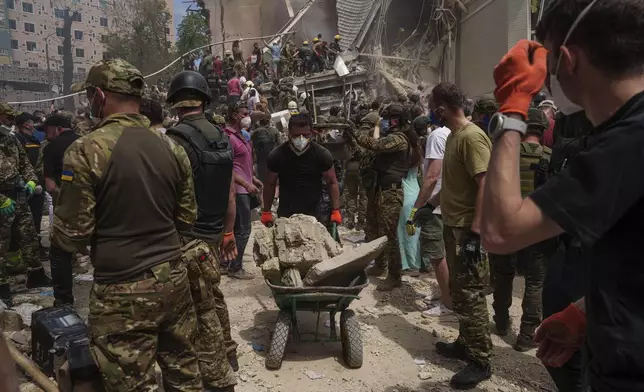 Rescue workers at the site of Okhmatdyt children’s hospital hit by Russian missiles, in Kyiv, Ukraine, Monday, July 8, 2024. Russian missiles have killed several people and struck a children’s hospital in the Ukrainian capital, Kyiv, authorities say. (AP Photo/Evgeniy Maloletka)