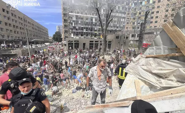 In this photo released by Ukrainian State Emergency Service, people and rescuers work at the site of Okhmatdyt children's hospital hit by Russian missiles, in Kyiv, Ukraine, Monday, July 8, 2024. Russian missiles have killed several people and struck a children's hospital in the Ukrainian capital, Kyiv, authorities say. (Ukrainian State Emergency Service via AP)