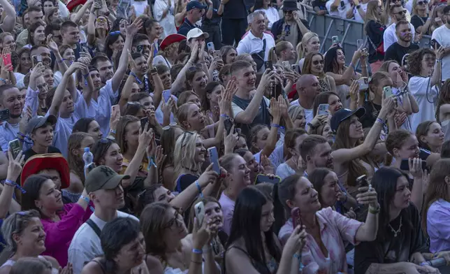 People enjoy a concert at the Atlas Festival in Kyiv, Ukraine, Sunday, July 21, 2024. This year, Ukraine's largest music festival struck a different chord. Gone were the international headliners, the massive performance halls and the hundreds of thousands of visitors. (AP Photo/Anton Shtuka)