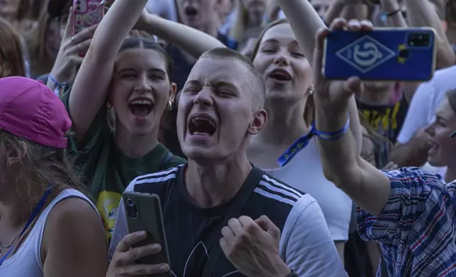 People enjoy a concert at the Atlas Festival in Kyiv, Ukraine, Sunday, July 21, 2024. This year, Ukraine's largest music festival struck a different chord. Gone were the international headliners, the massive performance halls and the hundreds of thousands of visitors. (AP Photo/Anton Shtuka)